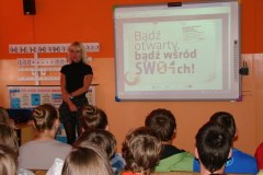 grupa_uczestnikow_tyl_prowadzacy_prezent.